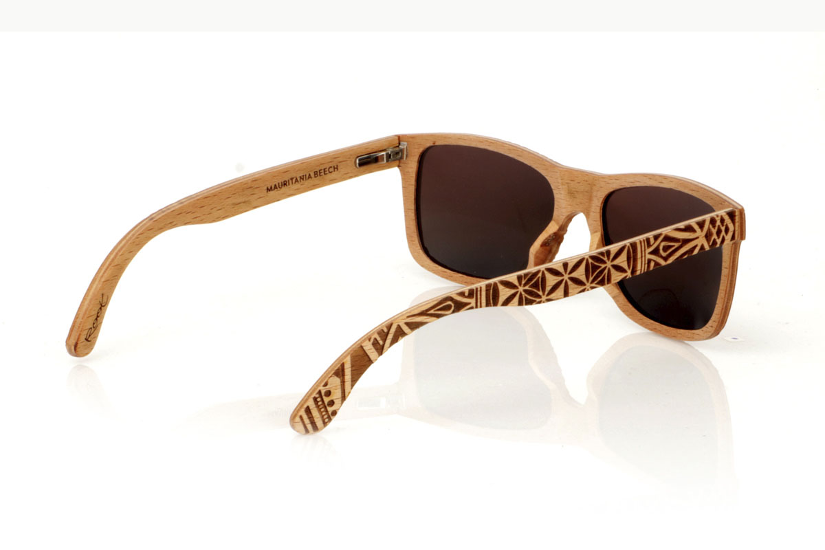 Wood eyewear of Beech MAURITANIA. The MAURITANIA wooden sunglasses have a shape inspired by the classics, made of beech wood. These glasses are distinguished by their exclusive finish engraved with an ethnic pattern, reflecting the arid tones of desert landscapes in every detail. Beech wood, in addition to its durability, provides a texture and color that makes each pair a unique piece. Designed for those looking for an accessory that stands out, the MAURITANIA are perfect for adding a touch of originality to your style. Measurement: 145x45. Caliber: 54. With them, you will take a piece of nature and adventure wherever you go. for Wholesale & Retail | Root Sunglasses® 